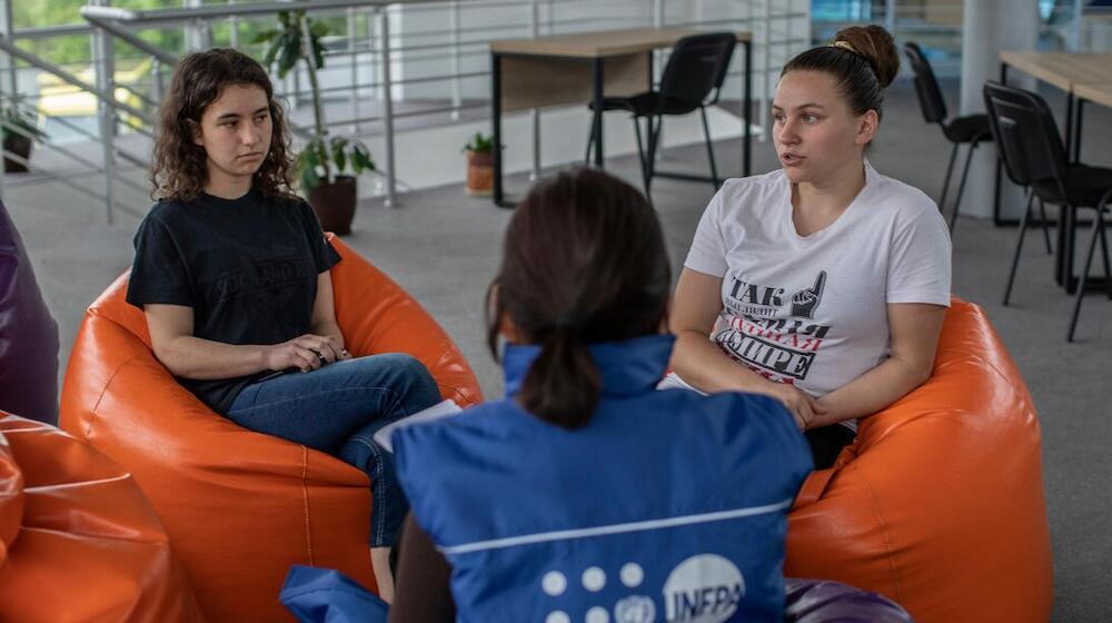 A UNFPA staff member consults with young women in a UNFPA Orange Safe Space of a refugee shelter in Chisinau, Moldova.