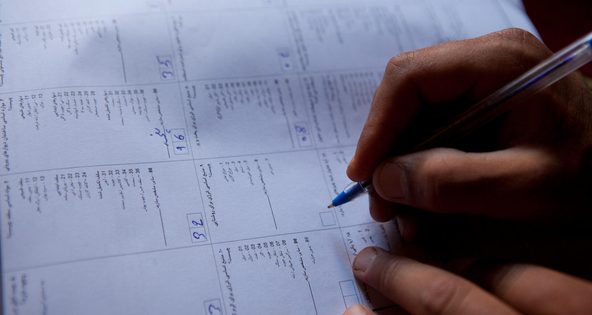A hand writes on a census paper.