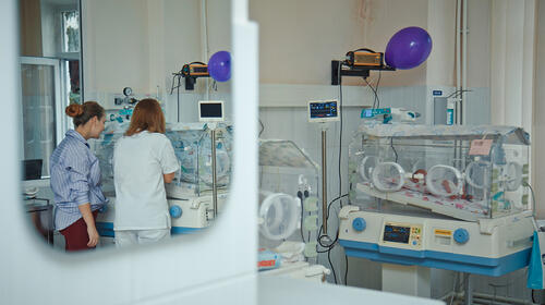 Two women stand side-by-side in an intensive care unit for newborns at the Gheorghe Paladi hospital.